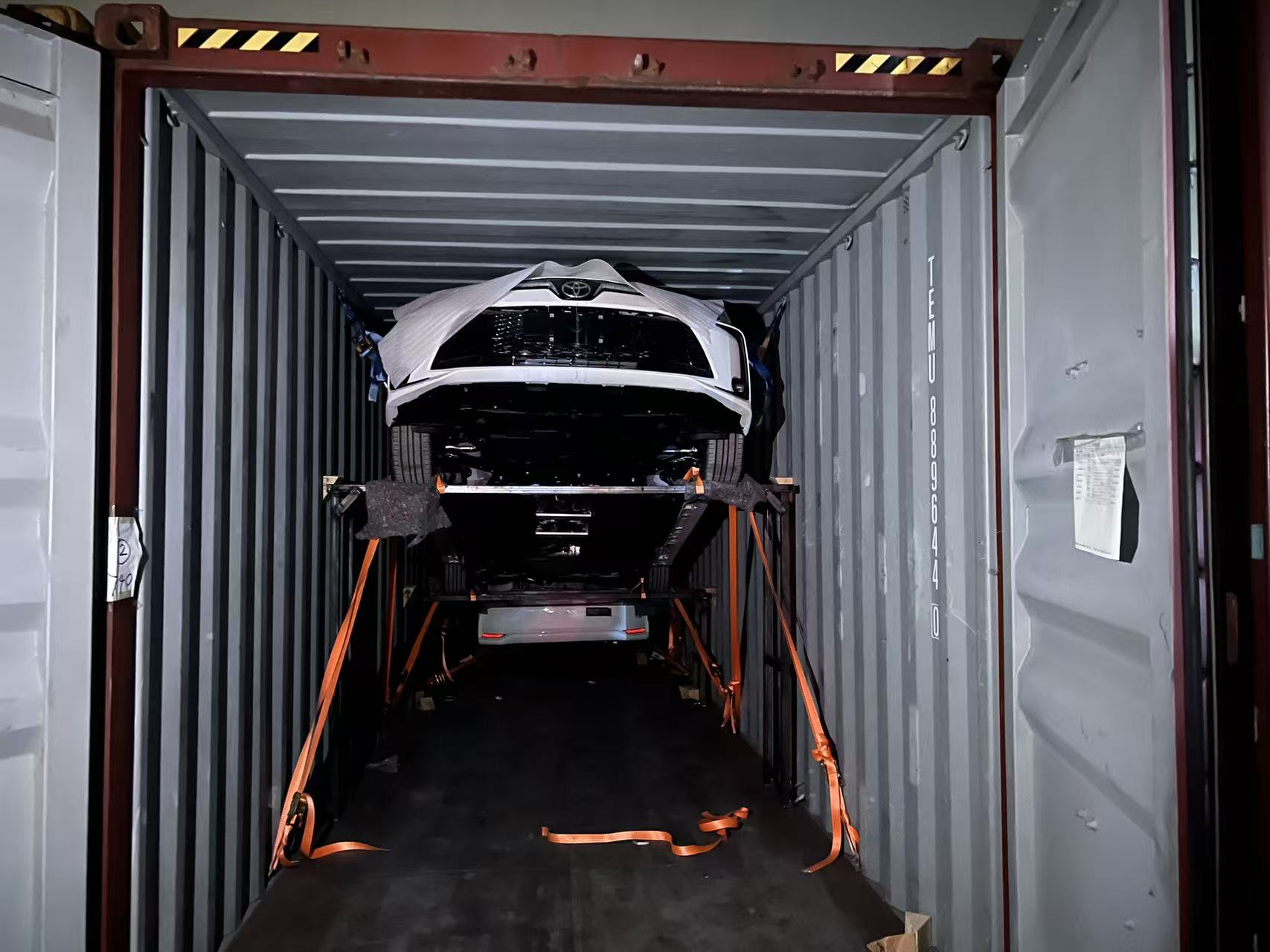 Vehicles fixed inside a container with straps